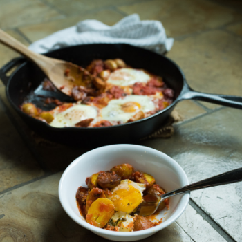 Poached eggs in cast iron with potatoes and marinara